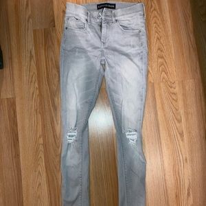 Grey mid-rise jeans with distressed knees